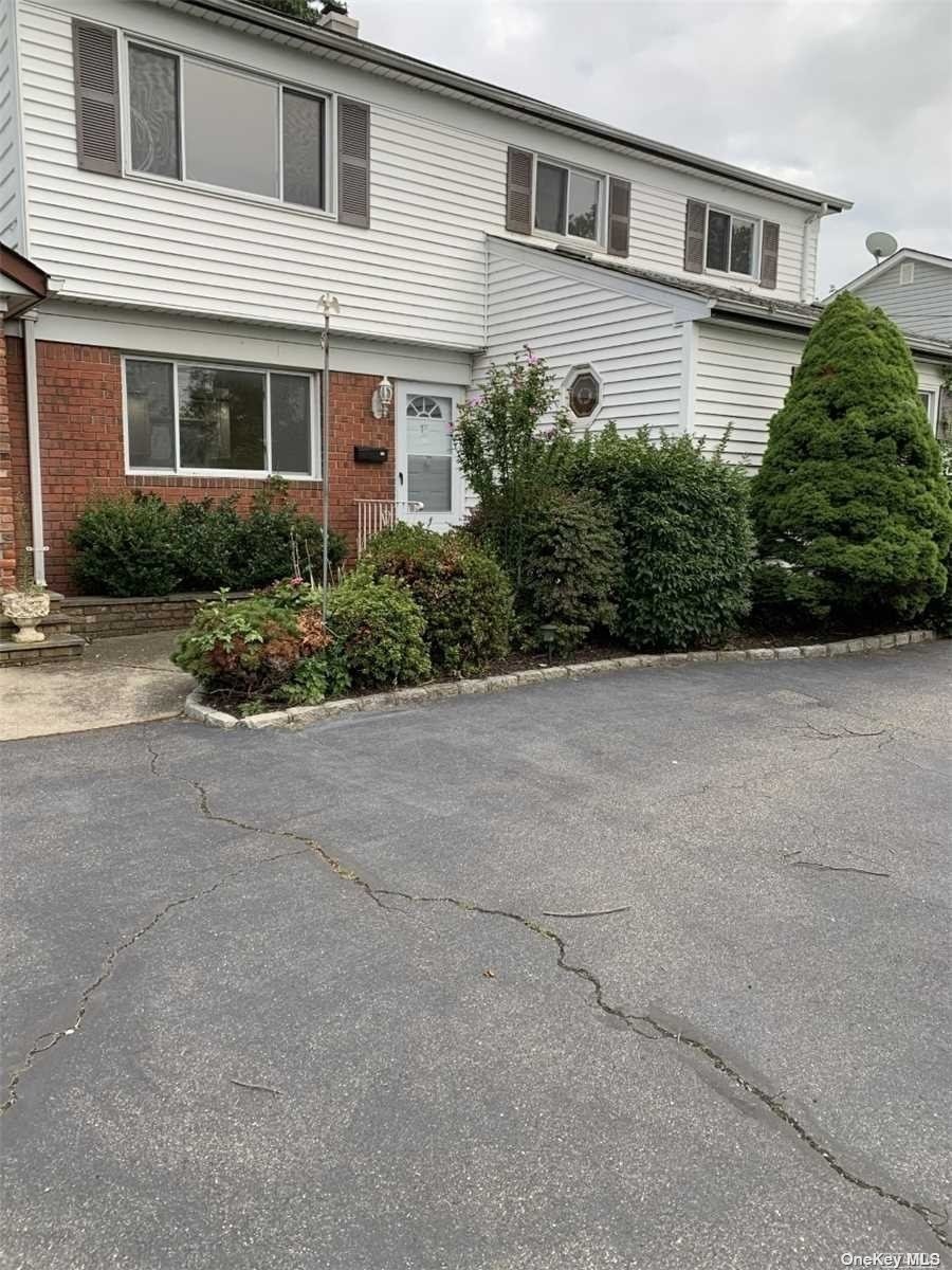 a front view of a house with a yard and potted plants