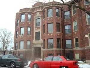 a front view of a building with car parked