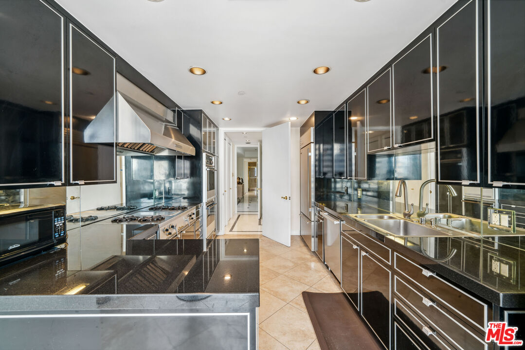 a kitchen with stainless steel appliances granite countertop a sink and a stove