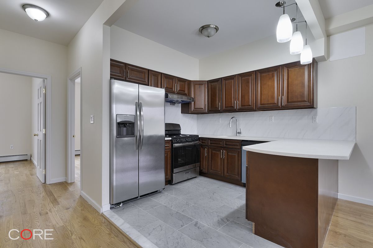 a kitchen with granite countertop a refrigerator and a sink