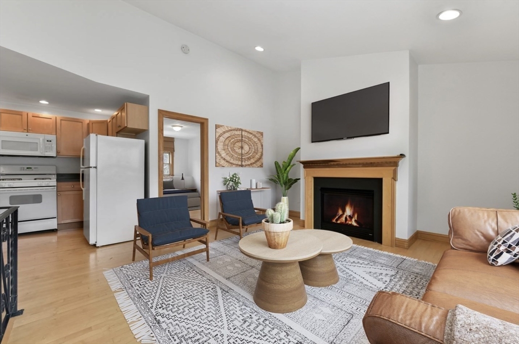 a living room with furniture a flat screen tv and a fireplace