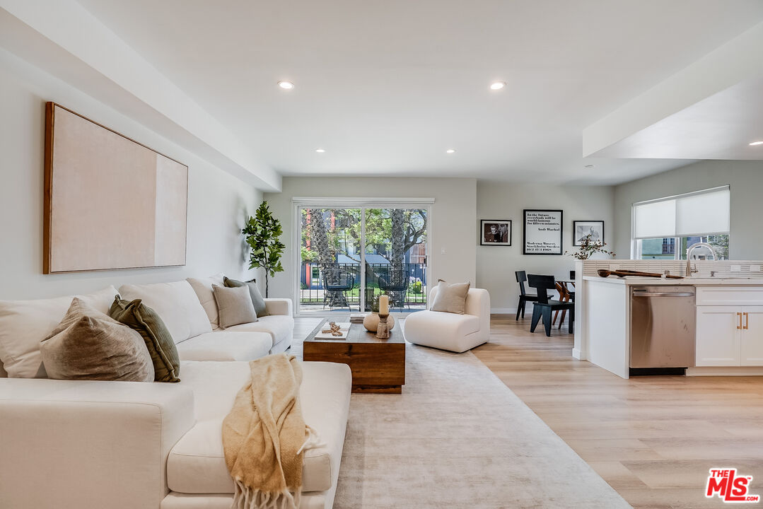 a living room with furniture and view of kitchen