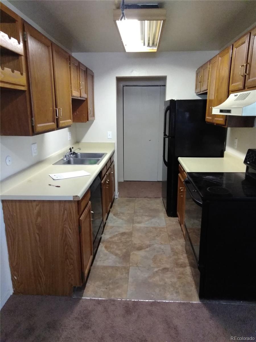 a kitchen with stainless steel appliances granite countertop a sink a stove and a refrigerator