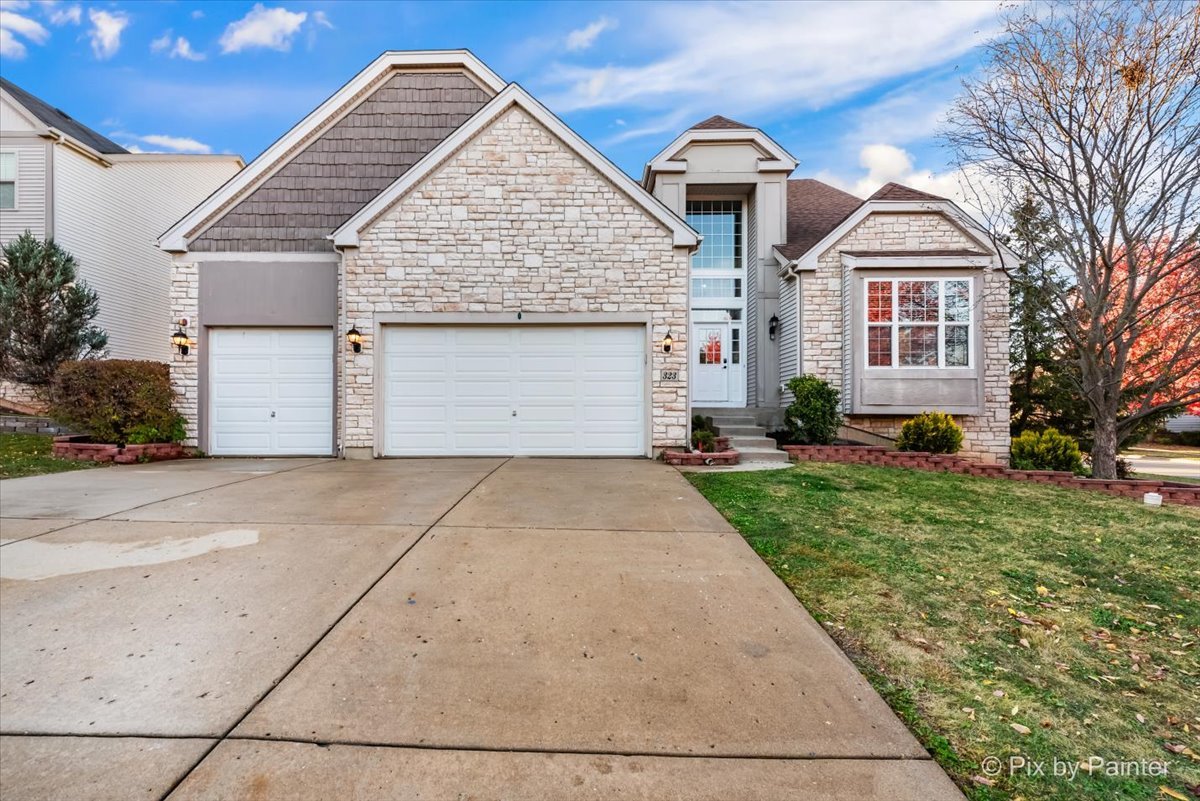 a front view of a house with a yard and garage