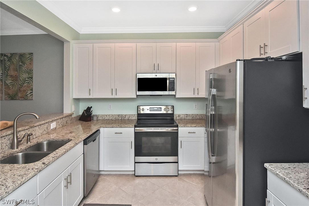 a kitchen with stainless steel appliances granite countertop a refrigerator stove and sink