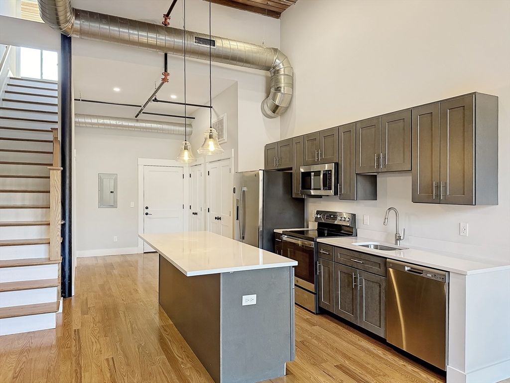 a kitchen with stainless steel appliances a sink and a refrigerator