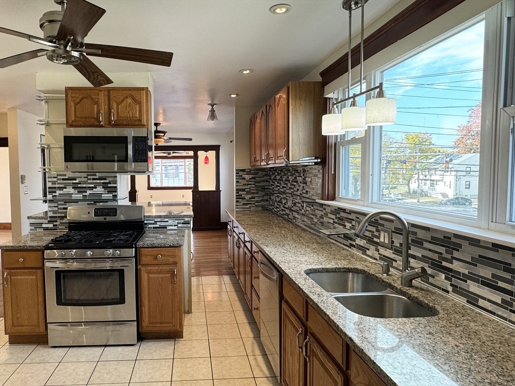 a kitchen with stainless steel appliances granite countertop a sink a stove and a refrigerator