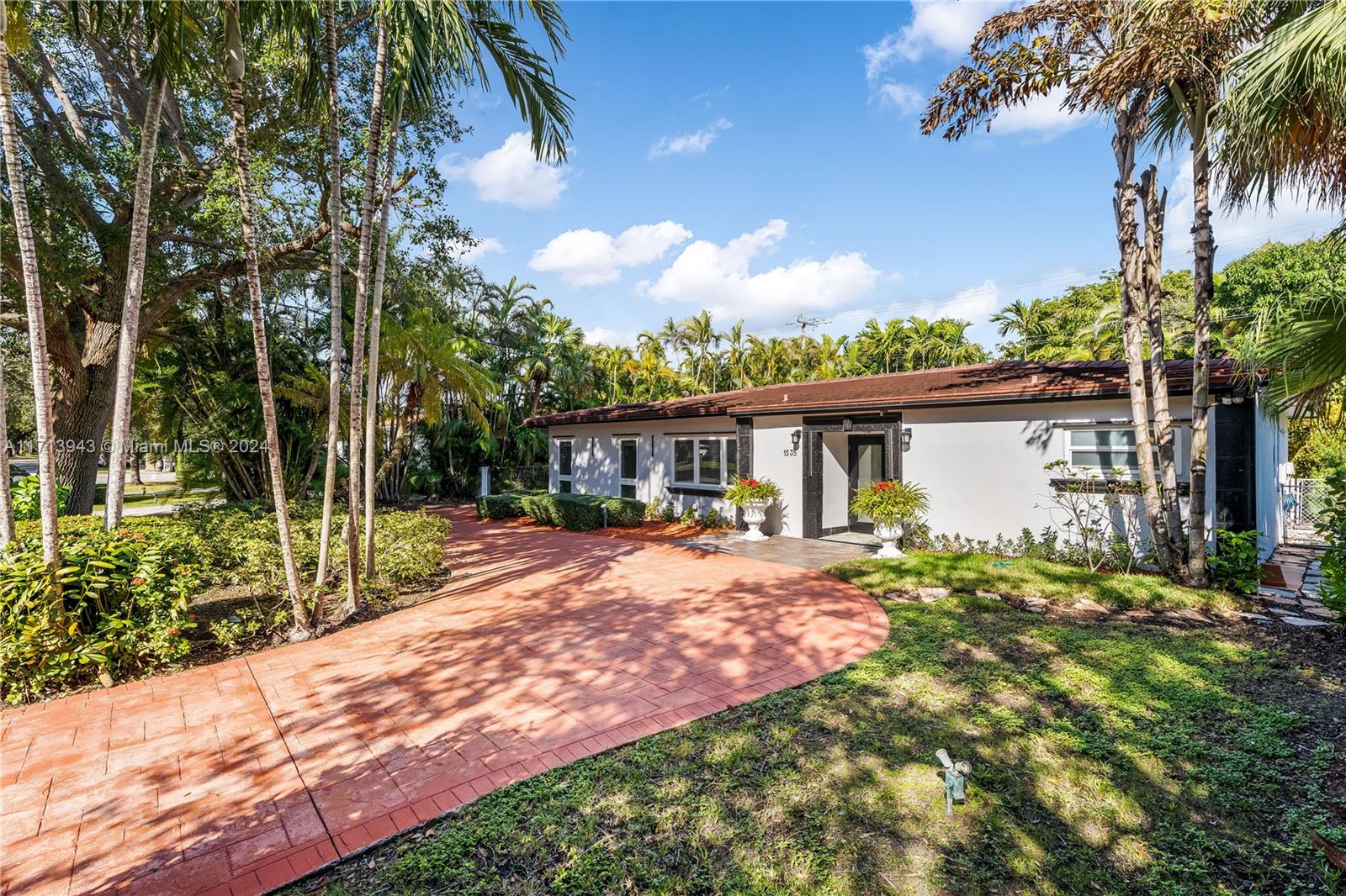 a front view of house with yard and trees around