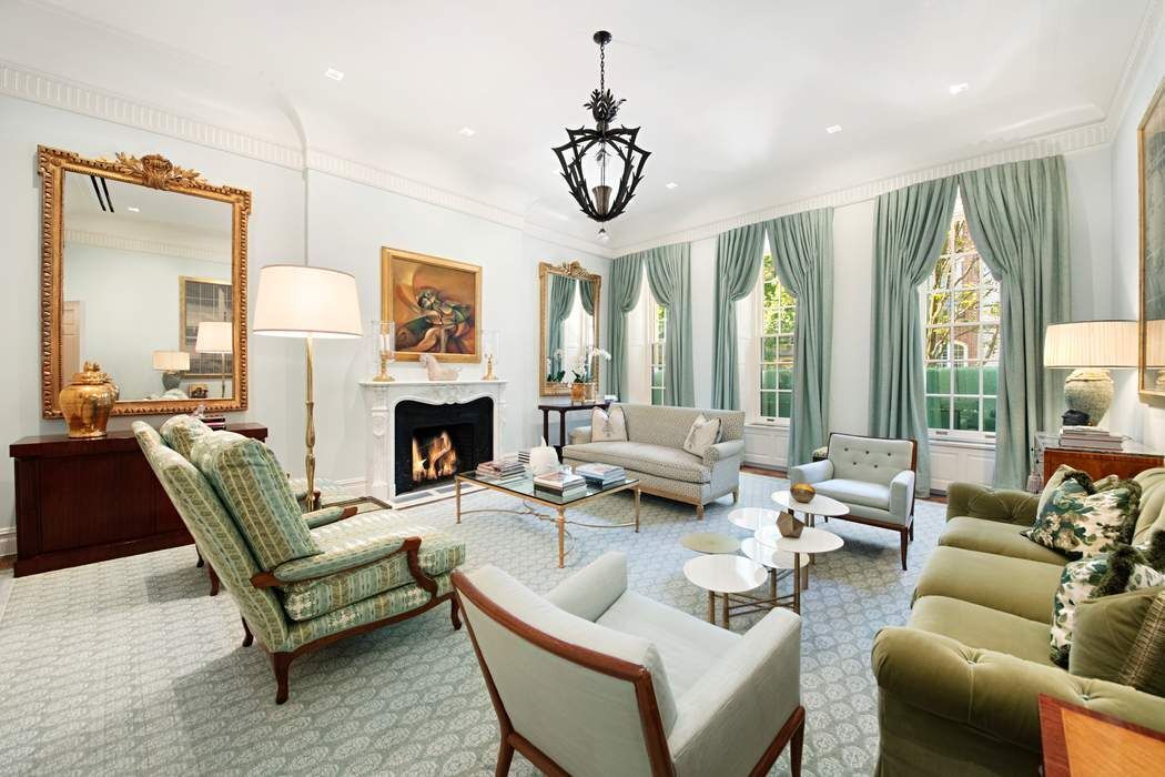 a living room with furniture a fireplace and a chandelier