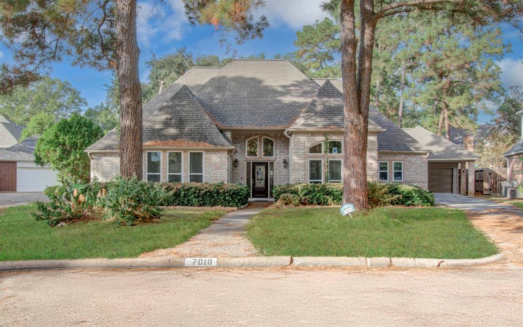 a front view of a house with a yard and potted plants