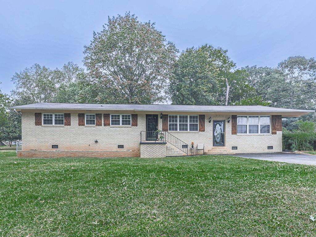 a front view of a house with a yard and trees