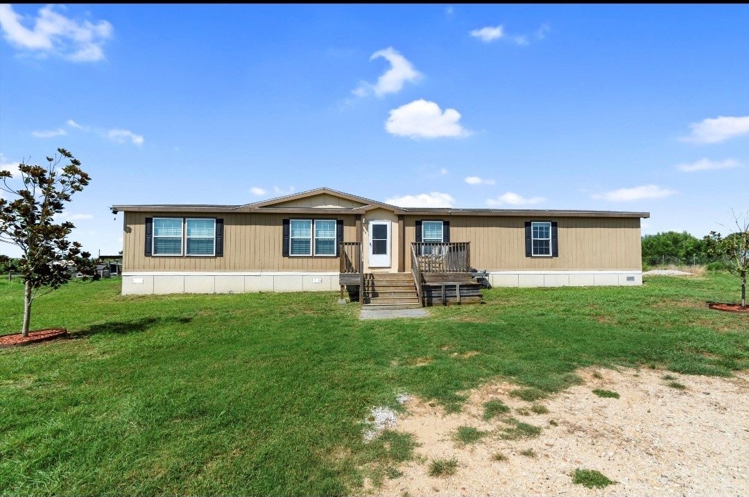 a front view of a house with yard and green space