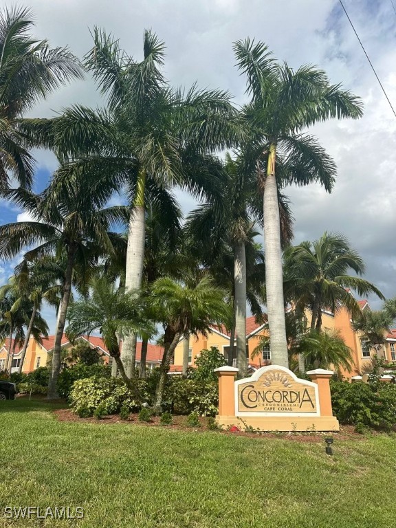 a view of a sign board and palm trees