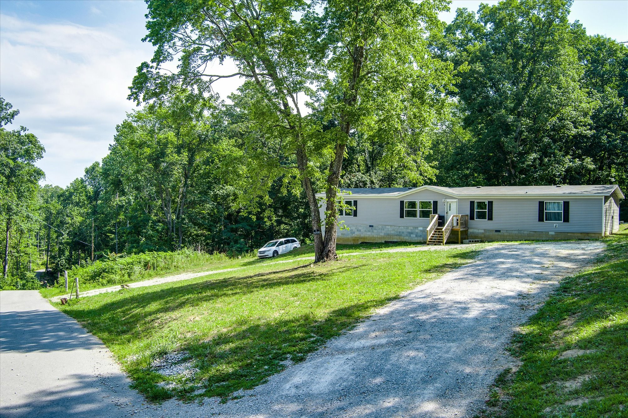 a front view of a house with a yard and a garden