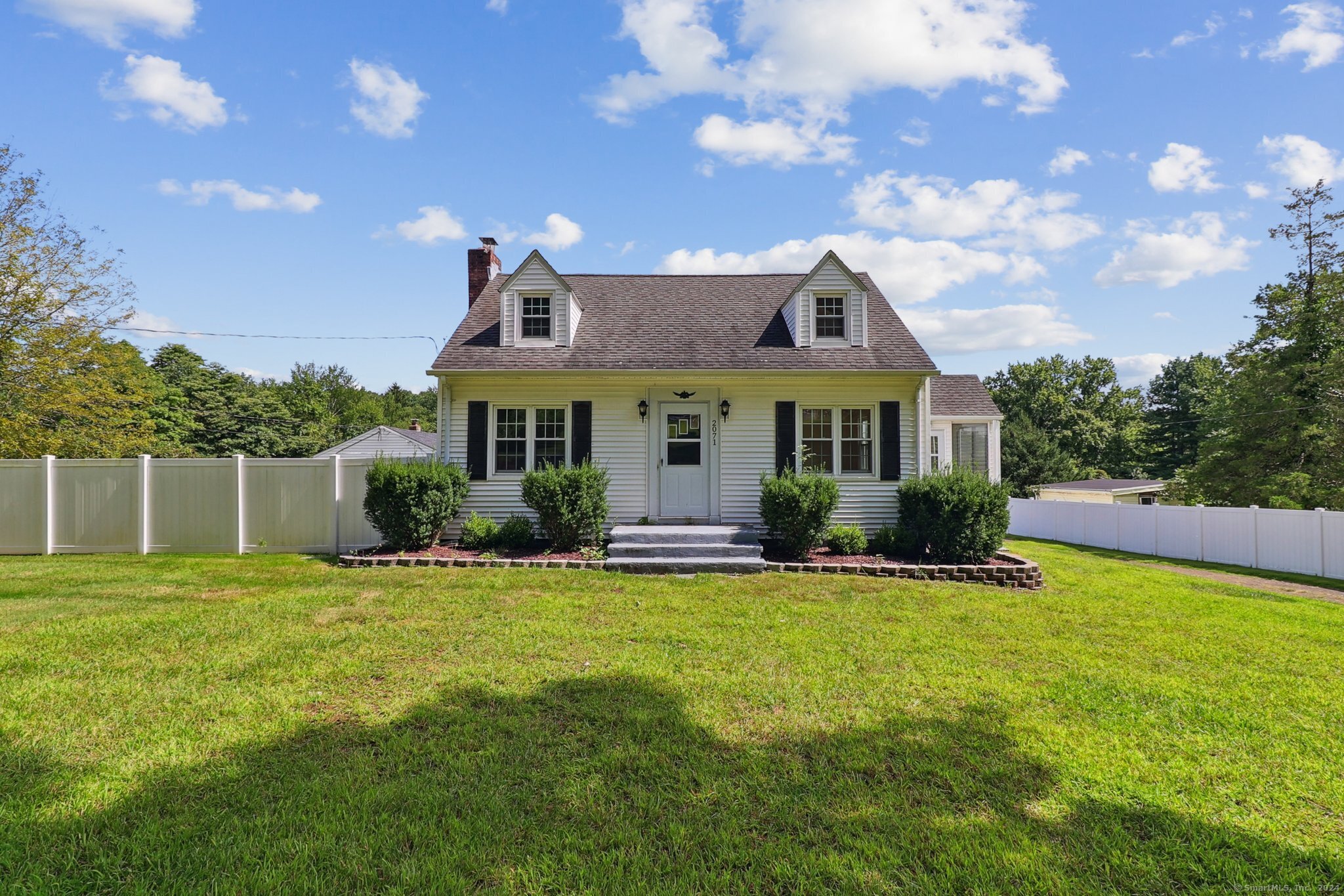 a front view of a house with a garden