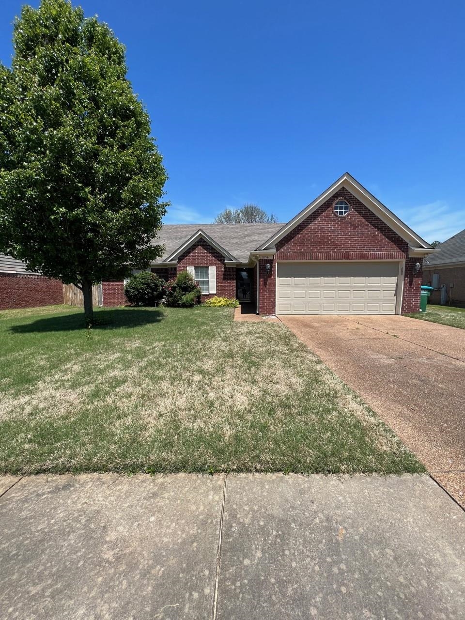 View of front of house with a garage and a front lawn