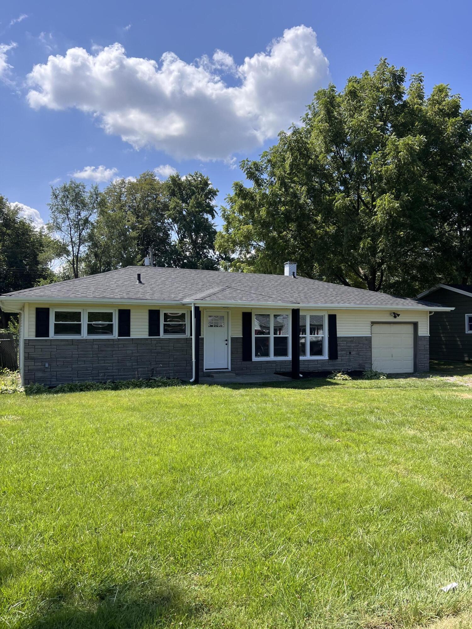 a front view of a house with yard and green space