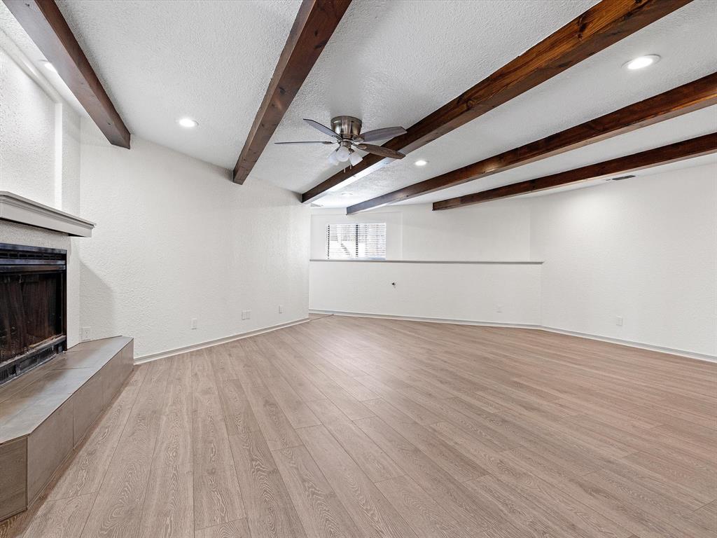 an empty room with wooden floor and fireplace