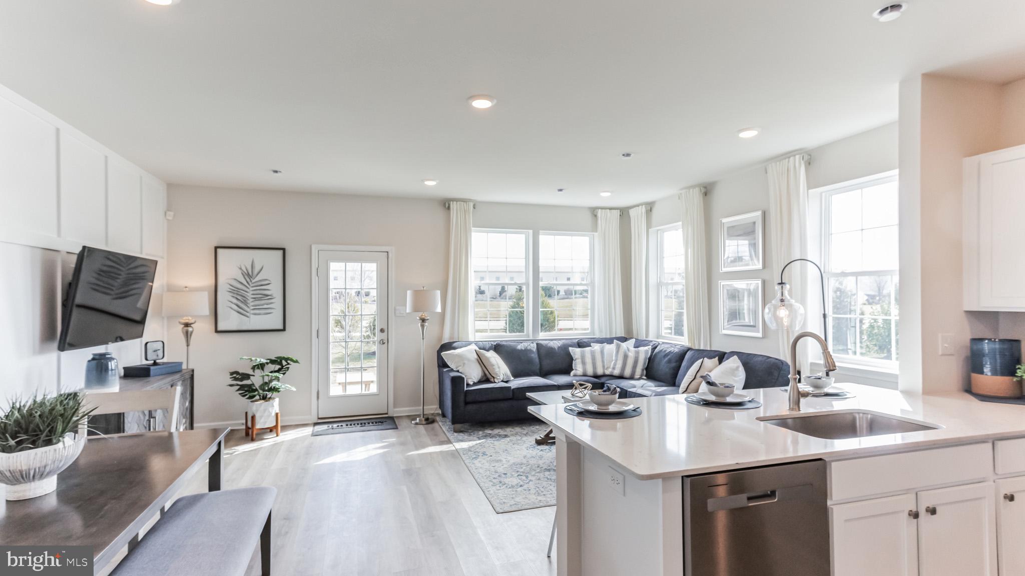 a living room with furniture flat screen tv and large window