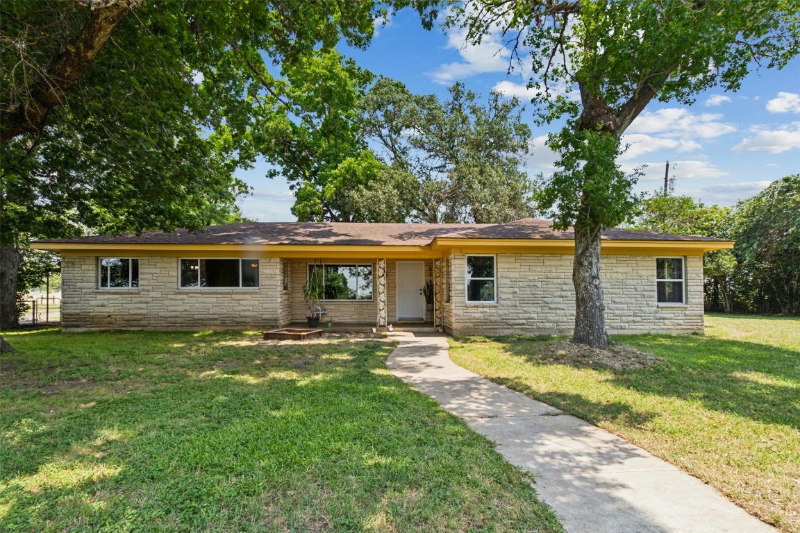 a view of a yard in front of a house with large trees