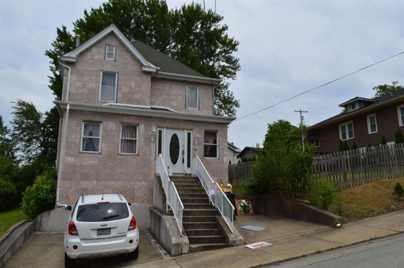 a car parked in front of a house with a small yard