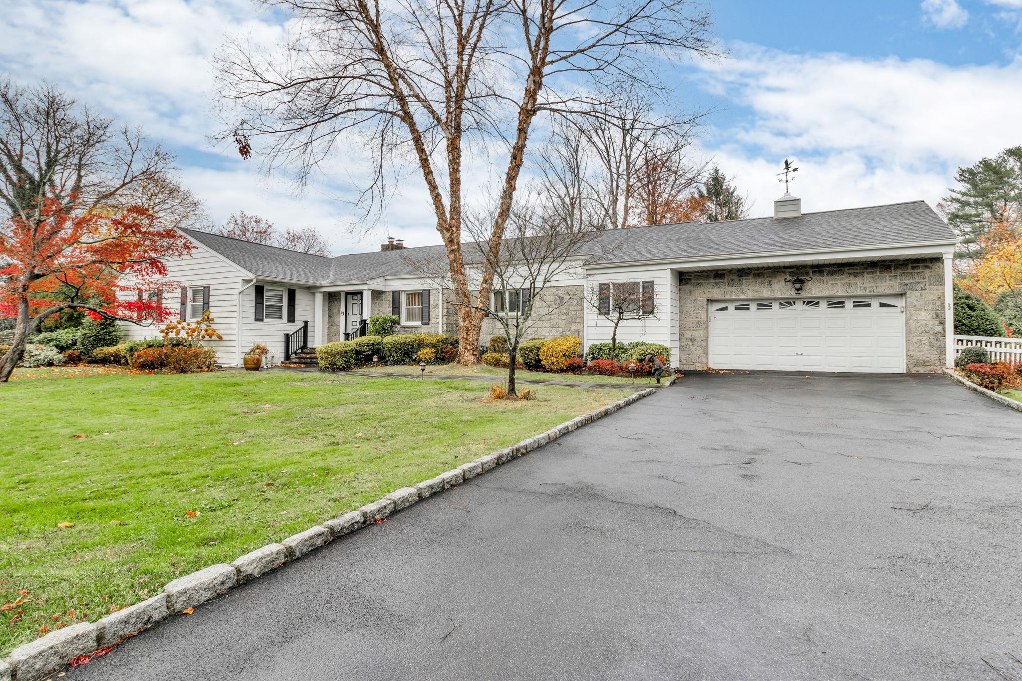 Ranch-style house featuring a garage and a front yard