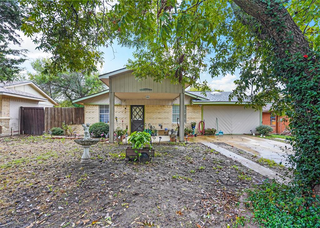 a front view of a house with a yard and a tree