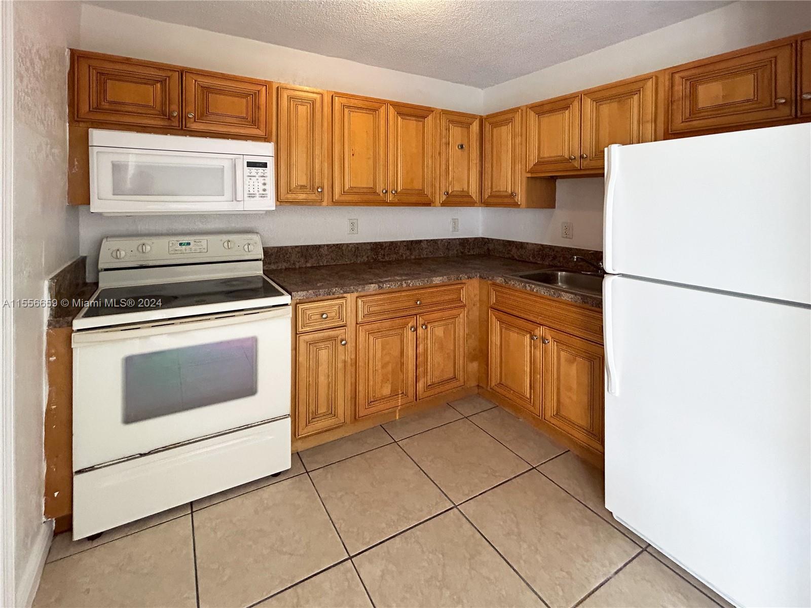 a kitchen with a stove top oven and cabinets