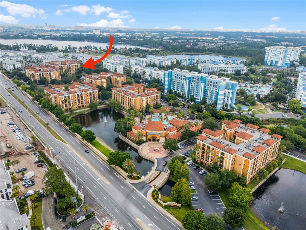 an aerial view of a city with lots of residential buildings ocean and mountain view in back