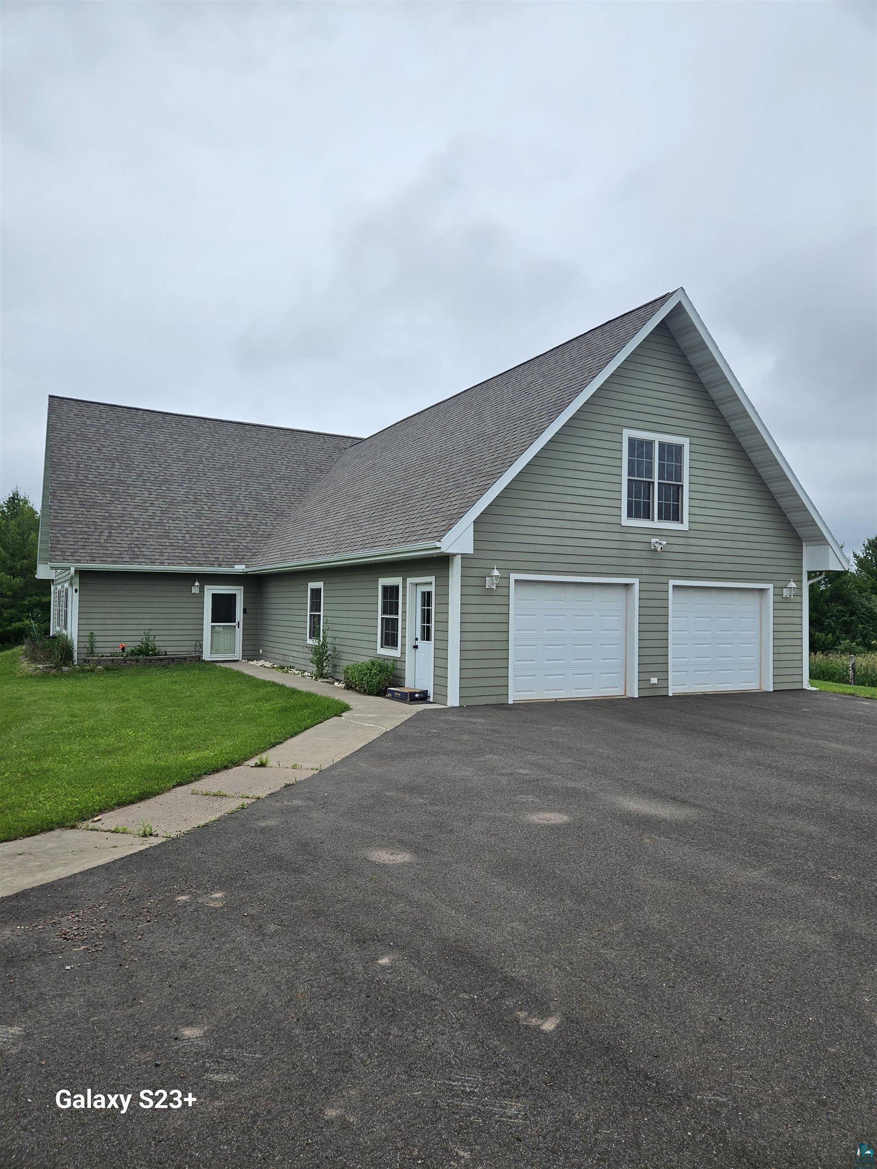 View of front facade featuring a garage and a front yard