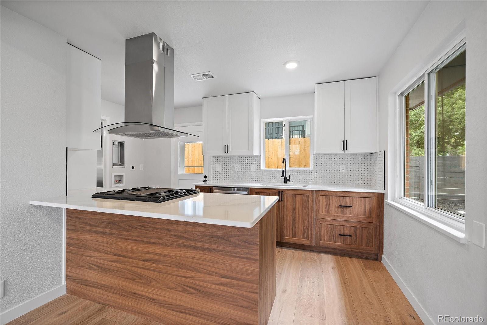 a kitchen with granite countertop a sink stove and cabinets