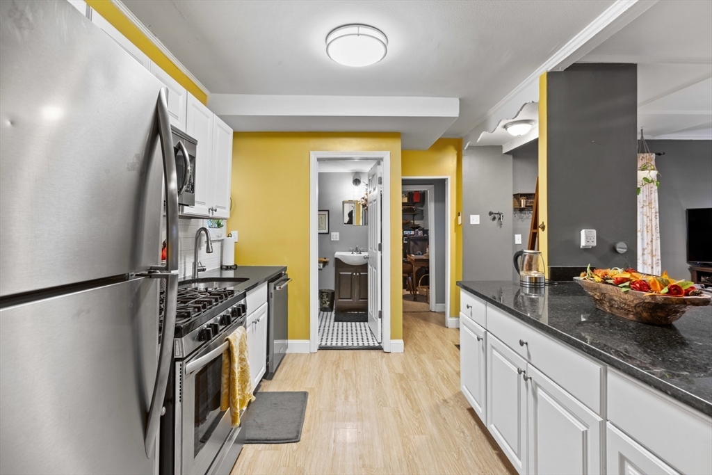 a kitchen with stainless steel appliances granite countertop a refrigerator and a sink