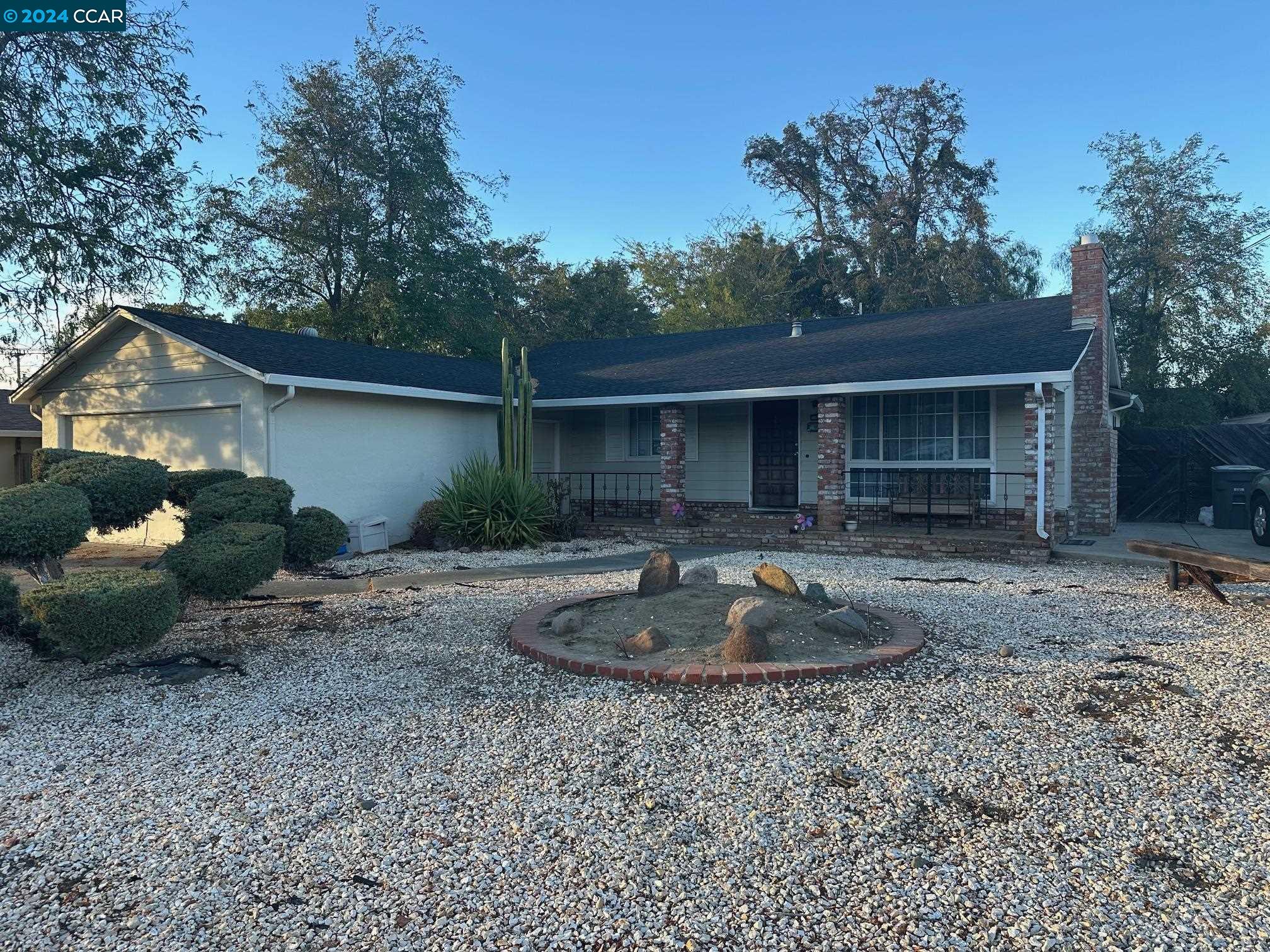 a front view of a house with a yard and trees