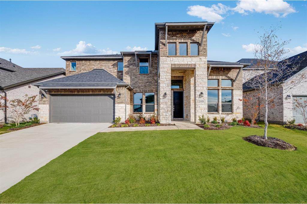 a front view of a house with a yard and garage