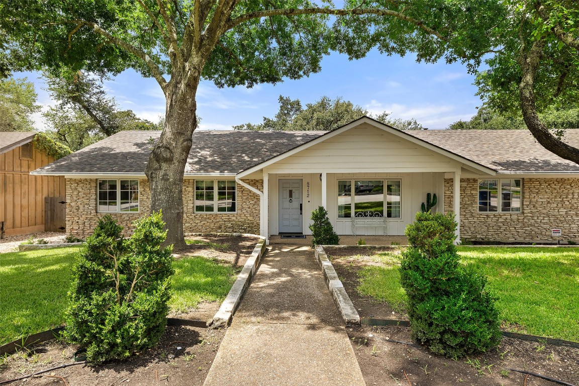 a front view of a house with a garden and yard