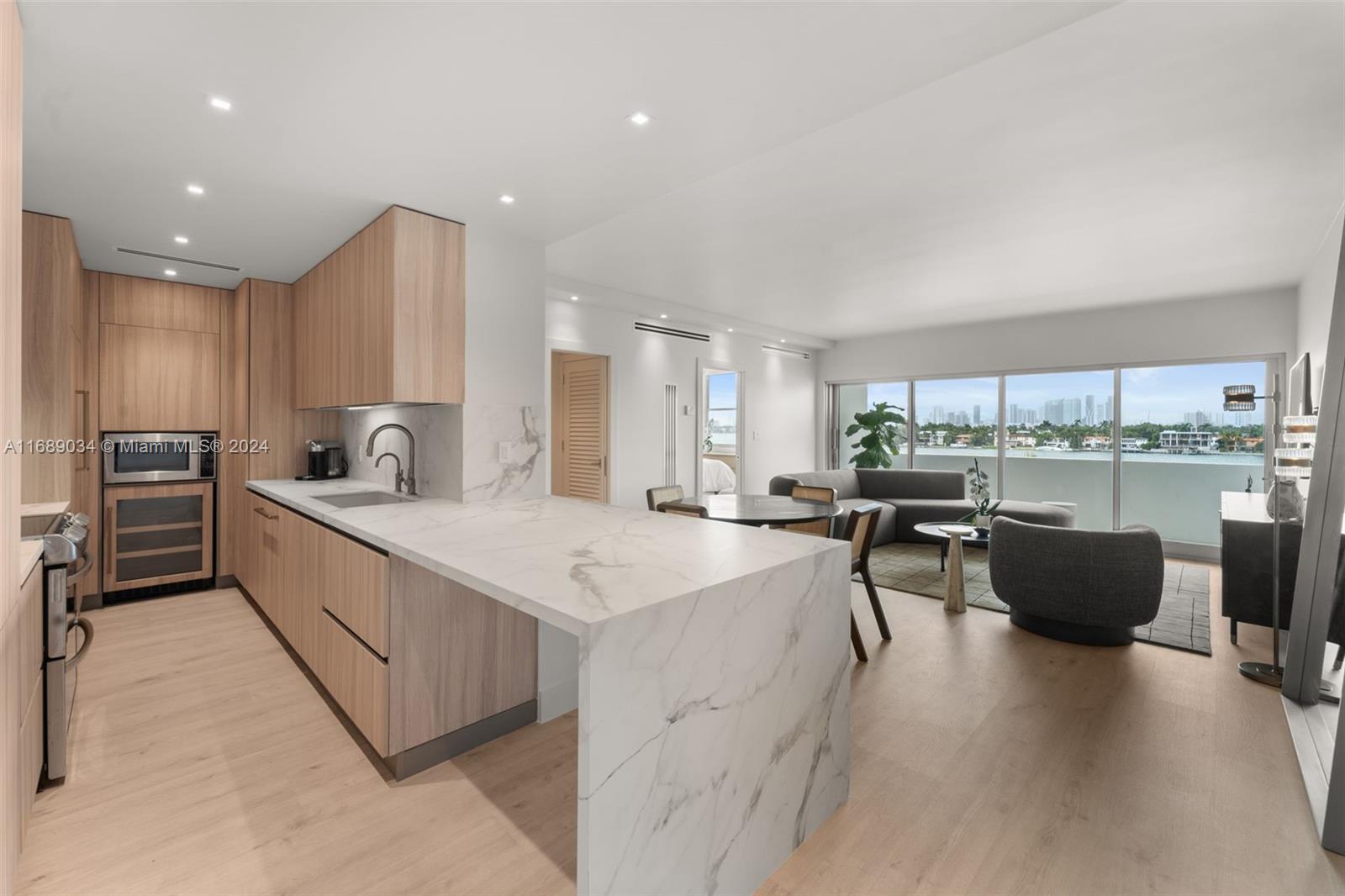 a kitchen with kitchen island a white counter top space a sink stainless steel appliances and cabinets