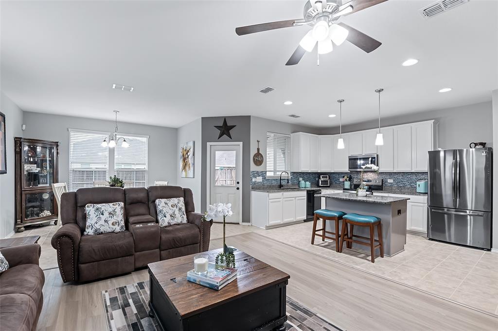 a living room with furniture kitchen view and a chandelier