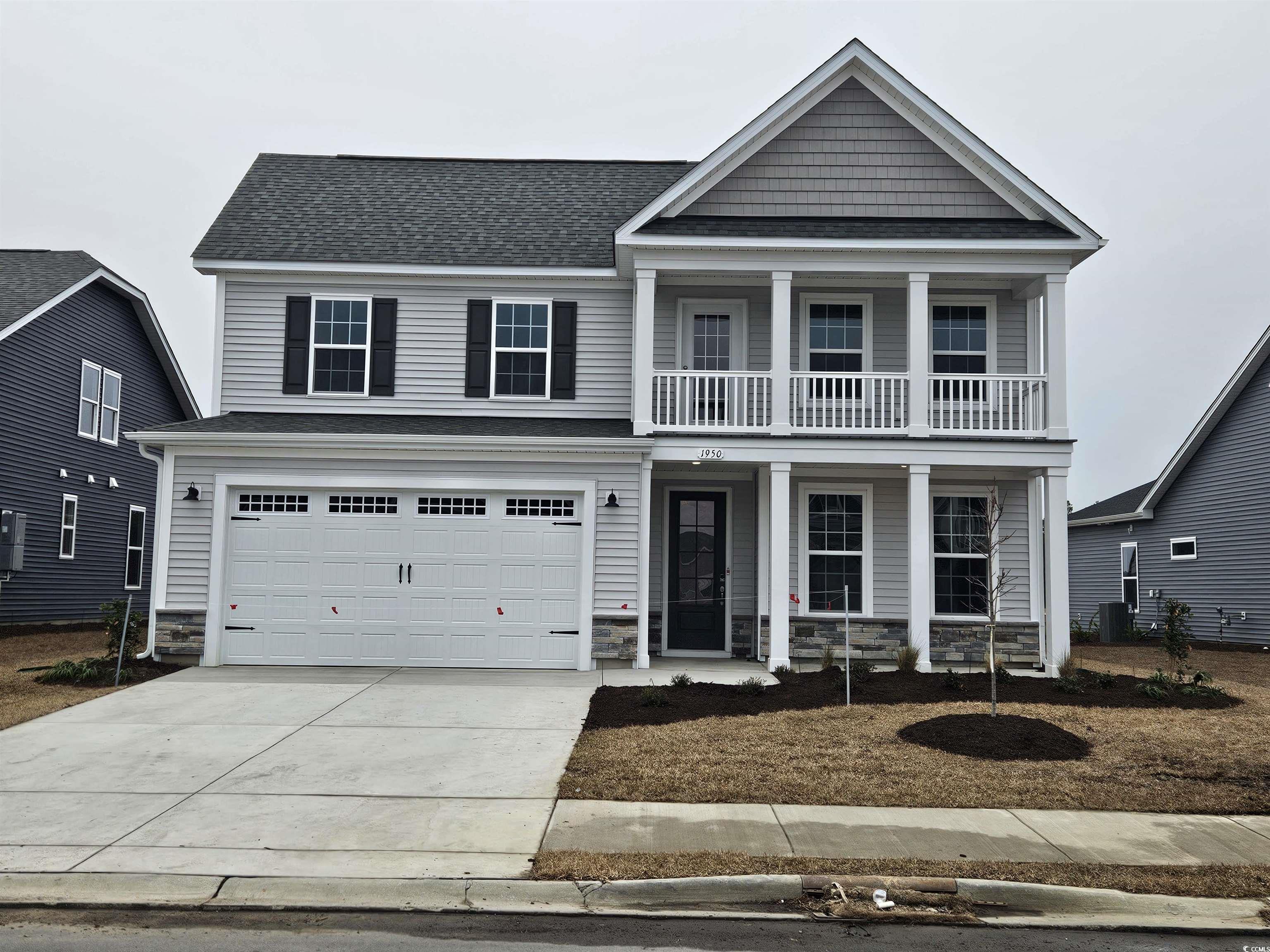 View of front facade with a garage, a balcony, and