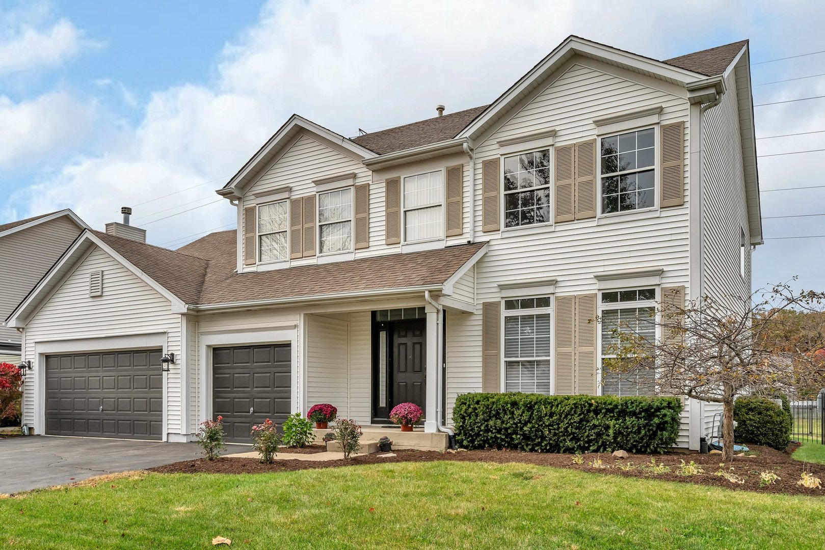 a front view of a house with yard and green space