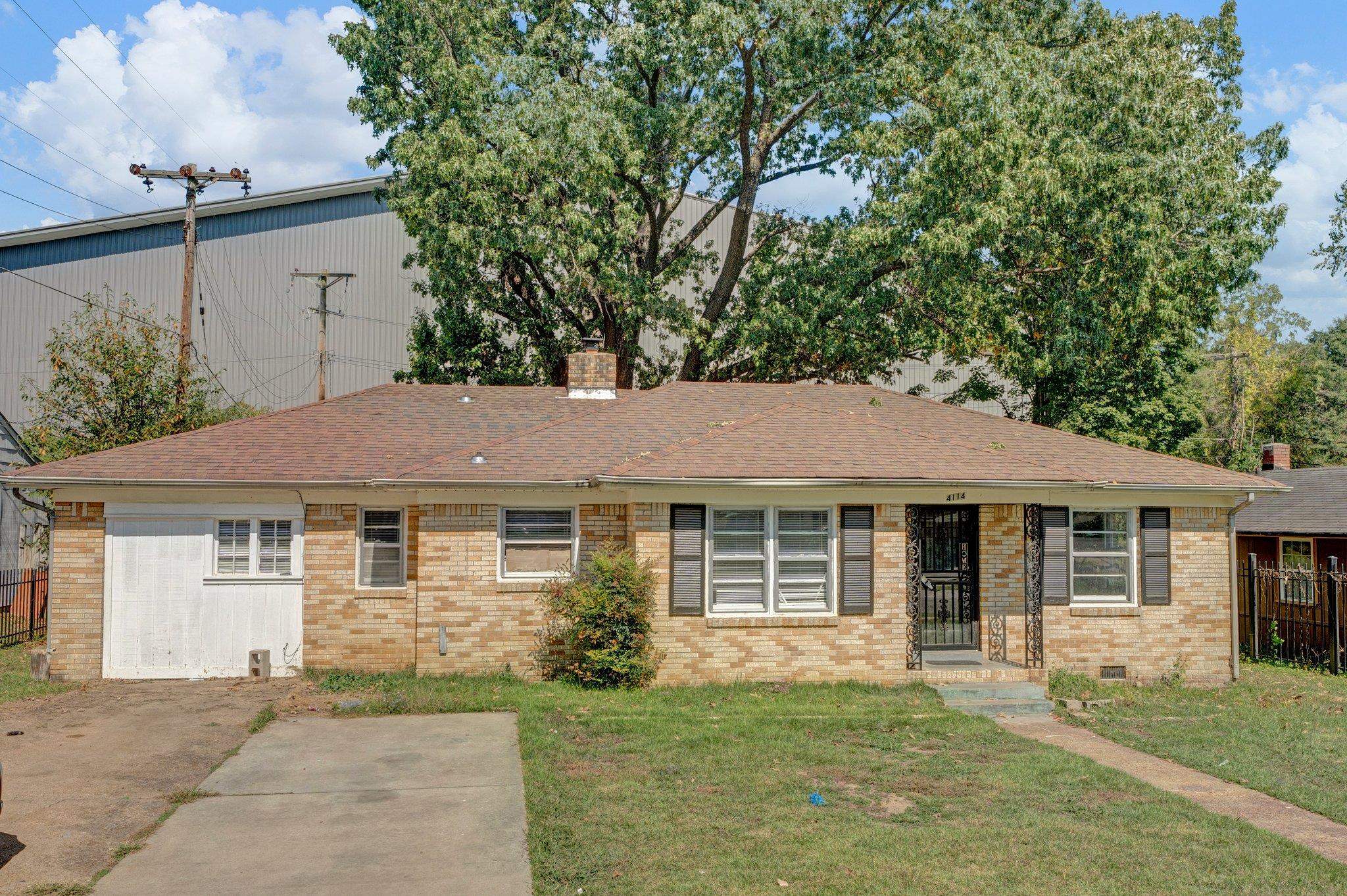 a front view of a house with a garden and yard