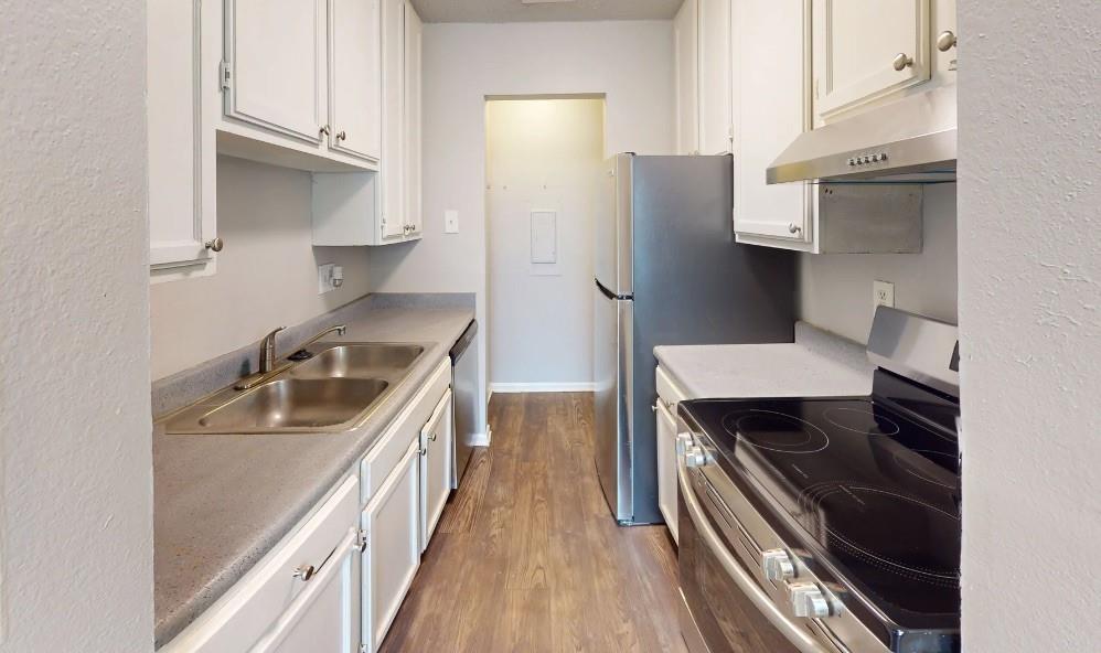 a kitchen with a sink appliances and cabinets