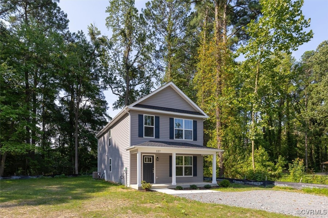 a front view of a house with a garden and yard