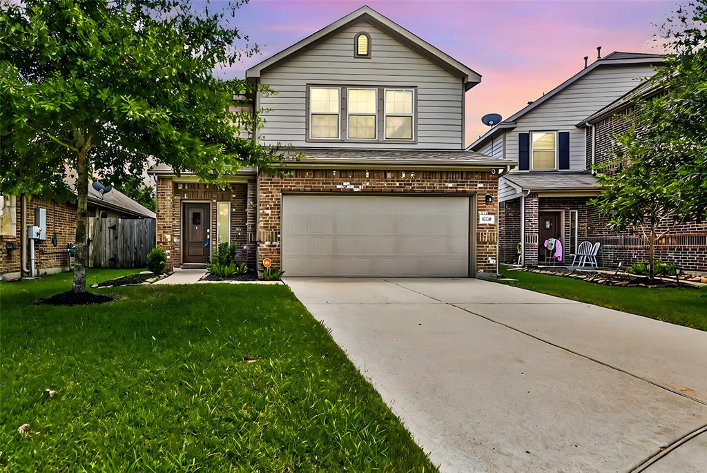 a front view of a house with a yard and garage