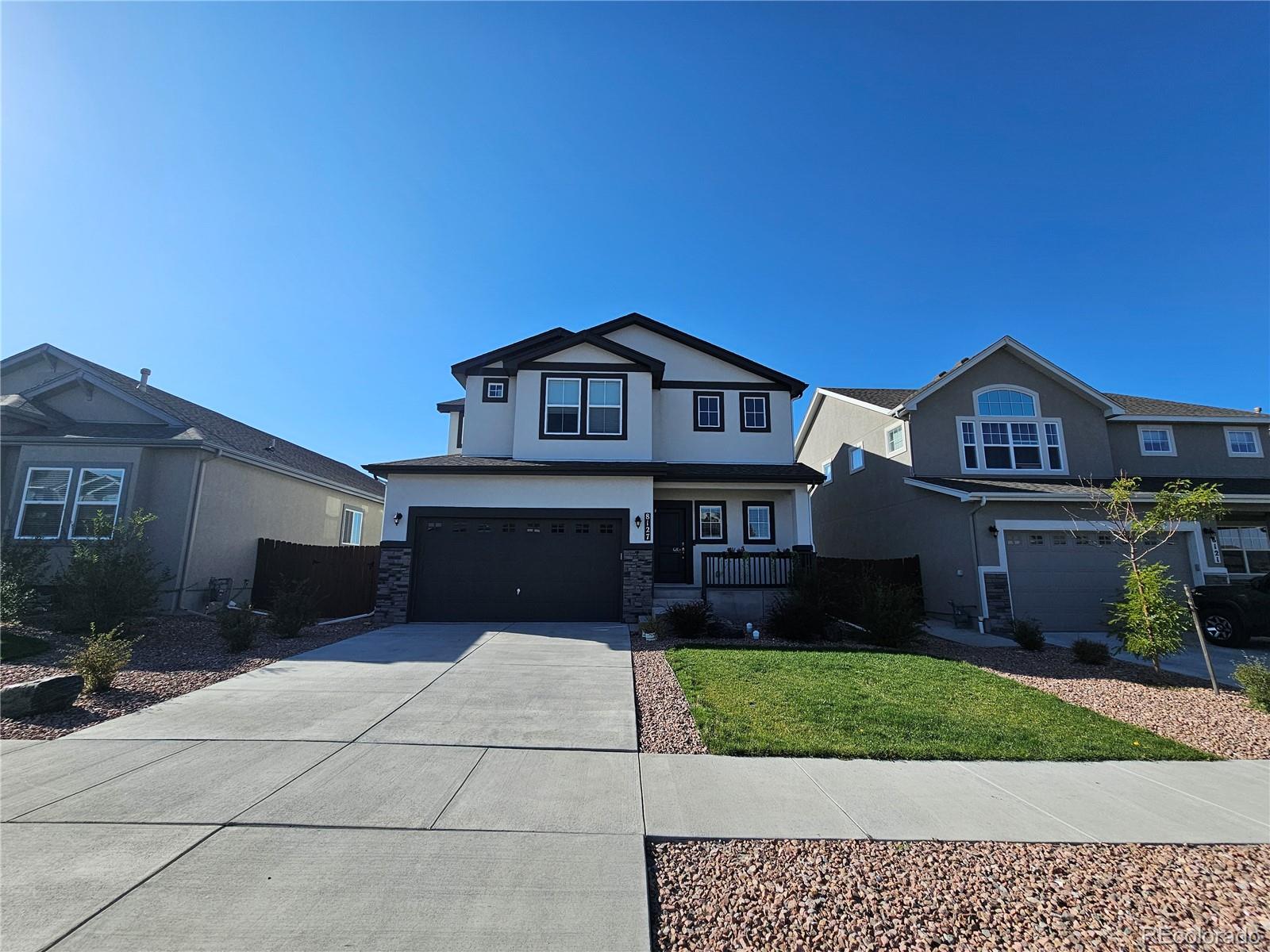 a front view of a house with a yard and garage