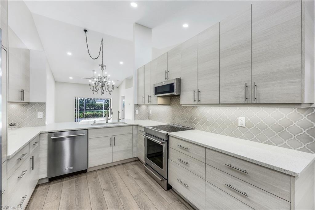 a kitchen with a sink a window and stainless steel appliances