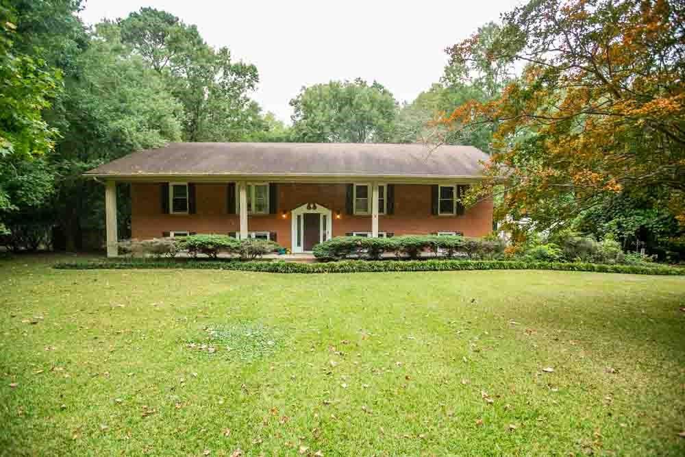 a front view of house with yard and trees