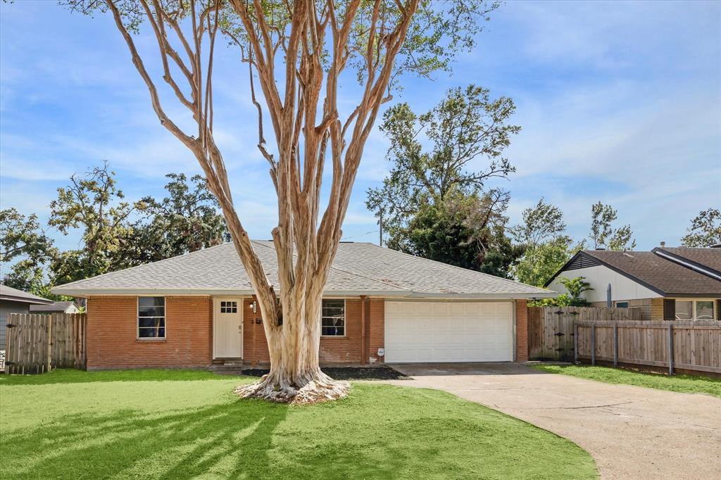 a front view of house with yard and trees in the background