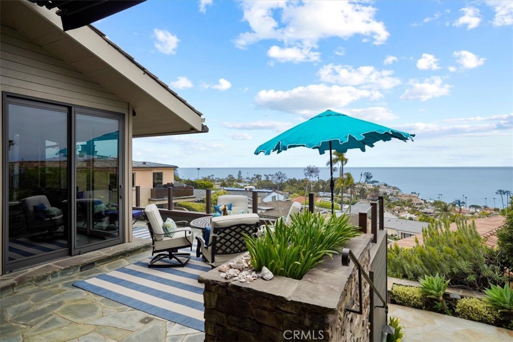 a roof deck with table and chairs under an umbrella