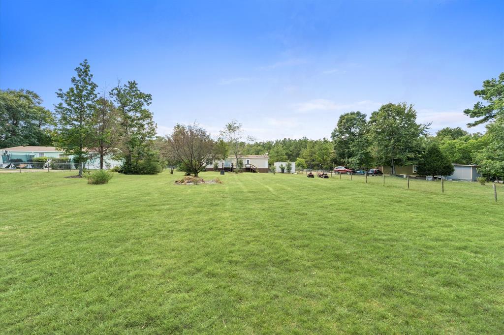 a grassy field with trees in the background