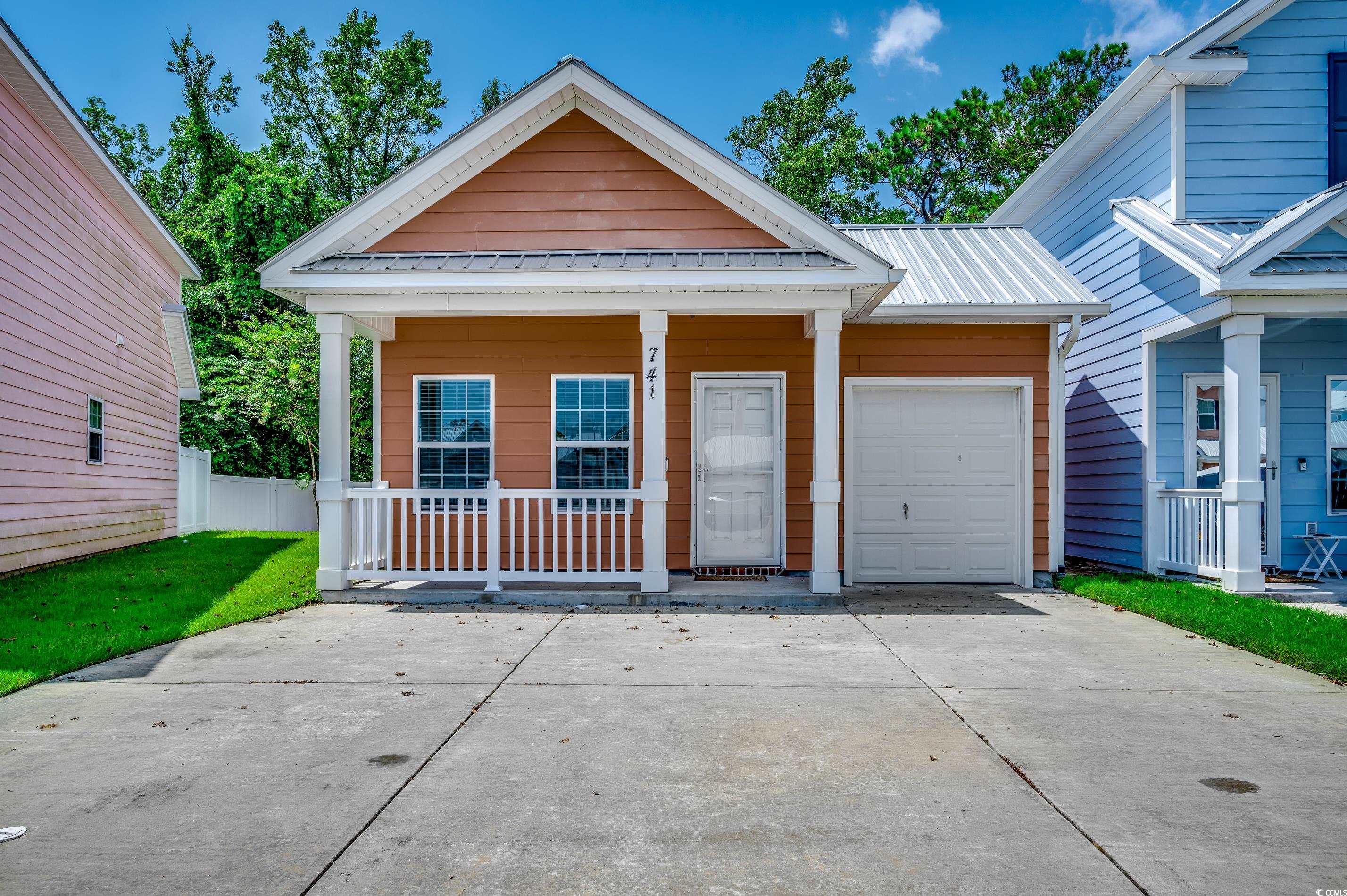 View of front of house featuring a porch and a gar